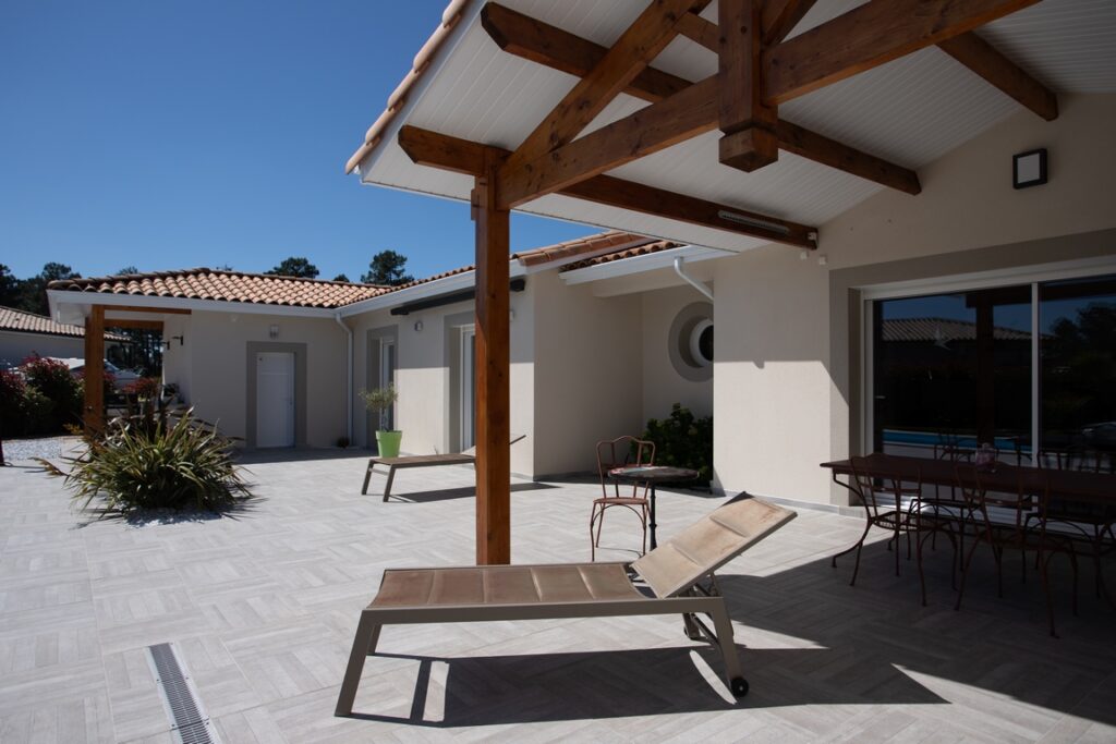 Une maison aux finitions de toit blanches et soignées.
